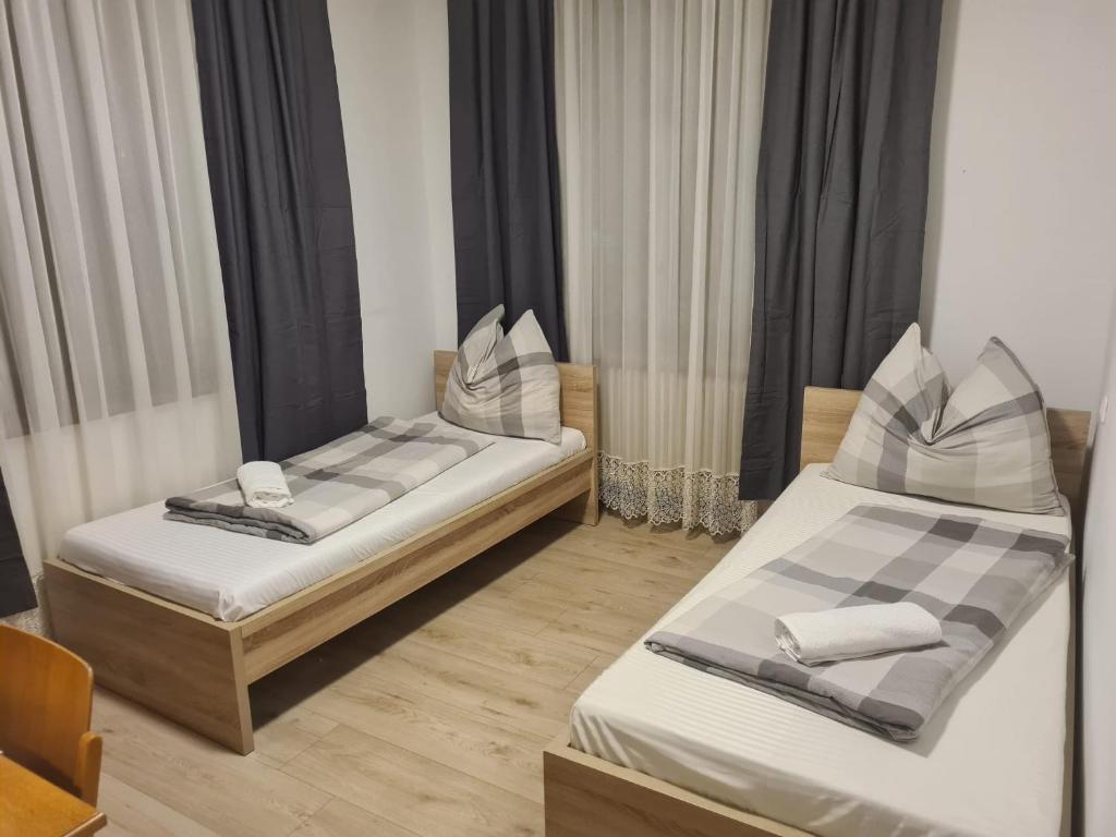 SchwanenstadtToskana Zimmer的带窗帘的客房内的两张单人床