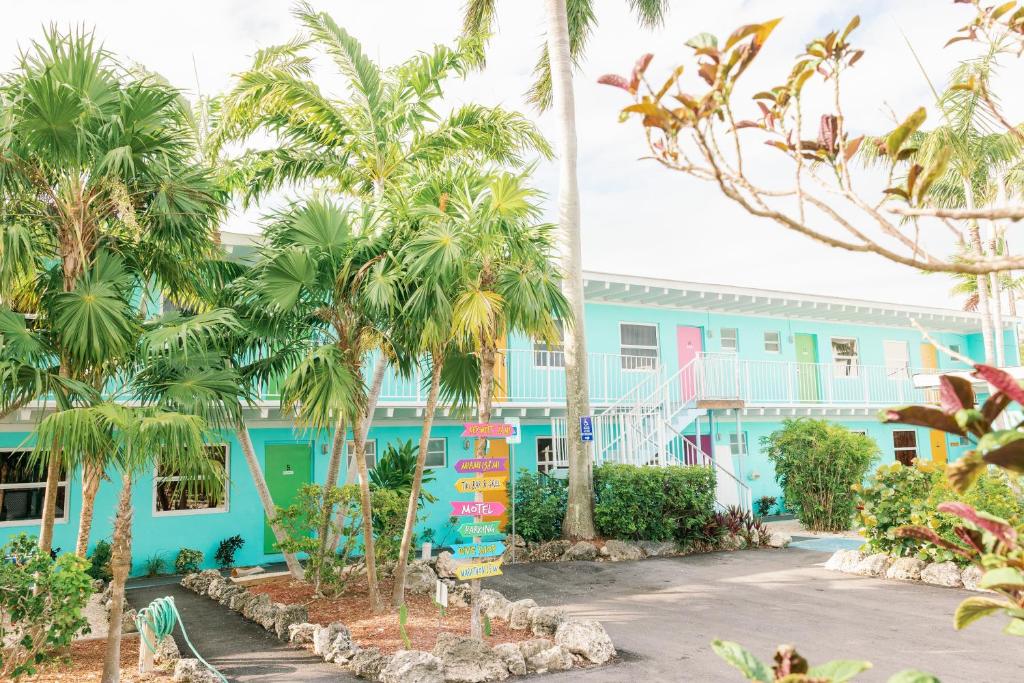Summerland Key卢港珊瑚礁度假酒店的一座蓝色的建筑,前面有棕榈树