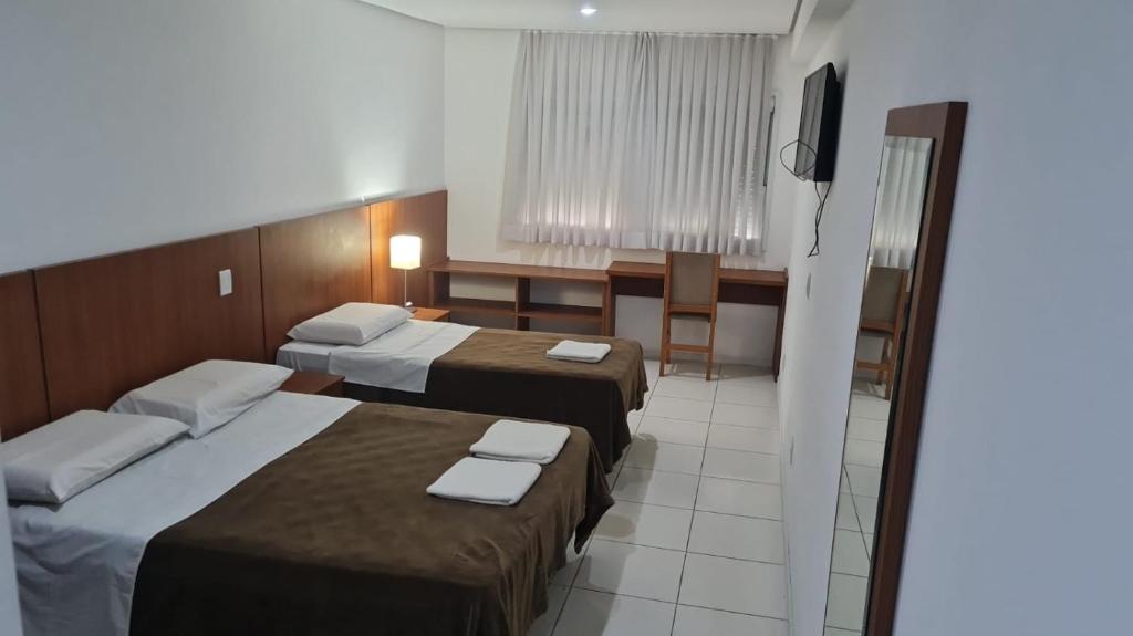 阿雷格里港HOTEL ECONOMICO - 150m Santa Casa, Prox Assembleia e UFRGS的酒店客房设有两张床和电视。