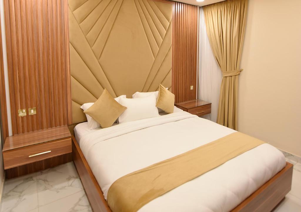 科威特الدانة للشقق الفندقية的一间卧室配有带白色床单和枕头的床。