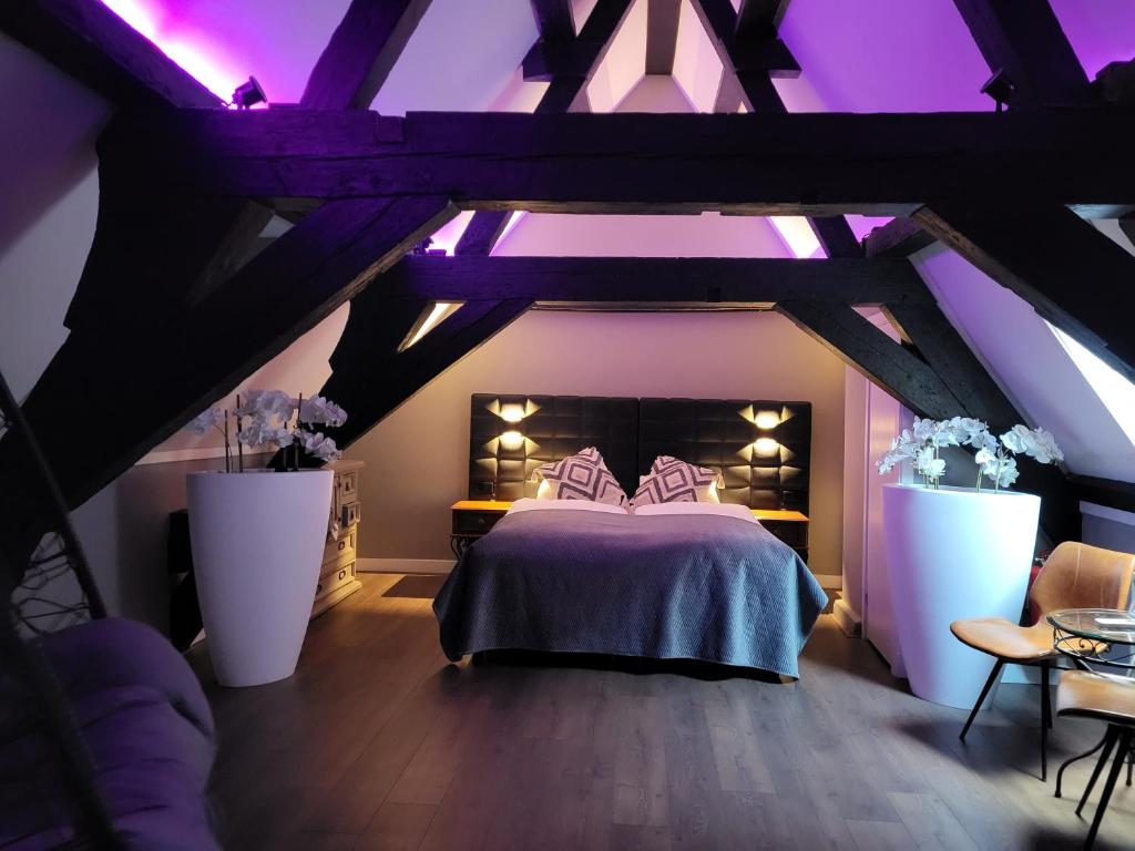 海牙Hotel Broer & Zus的阁楼卧室配有一张床和紫色照明