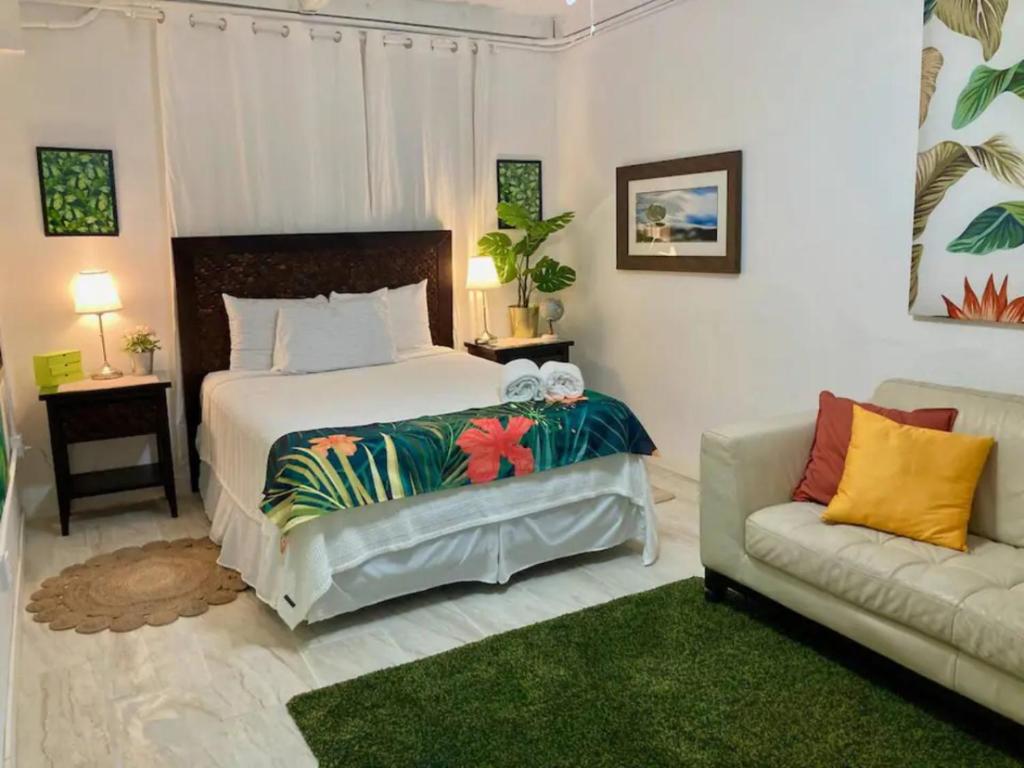 圣胡安Tropical Apartments in Miramar的一间卧室配有一张大床和一张沙发