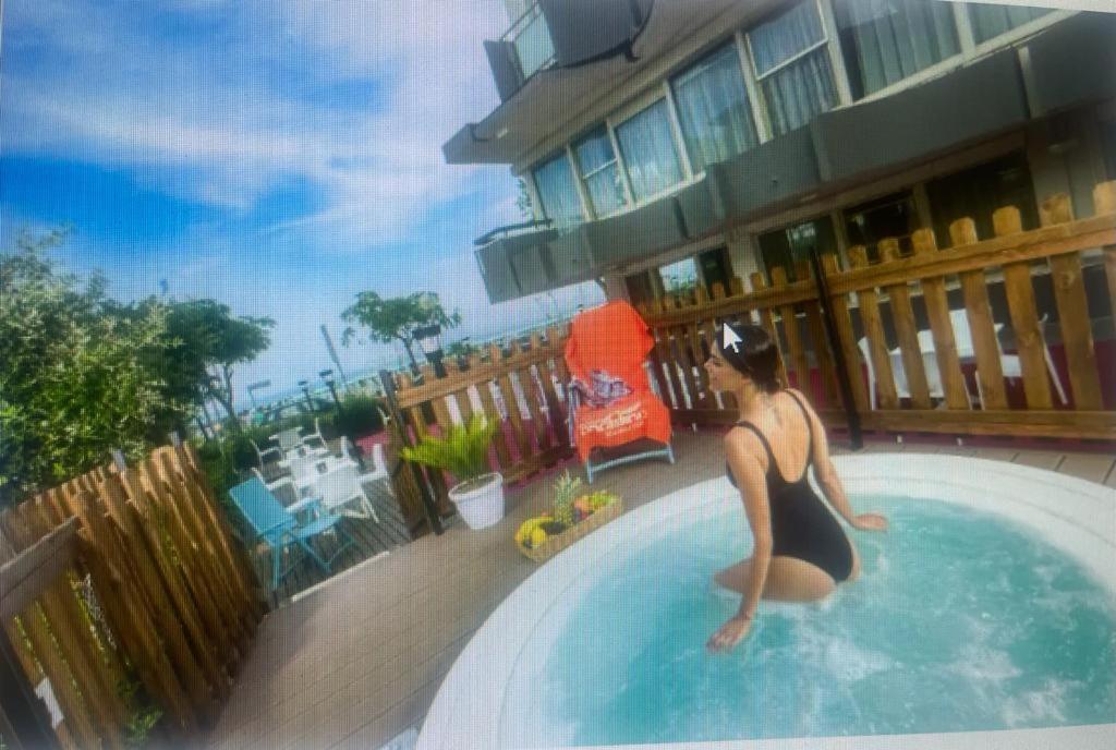 里米尼Hotel Tyc Soleti Hotels的坐在游泳池里穿着泳衣的女人