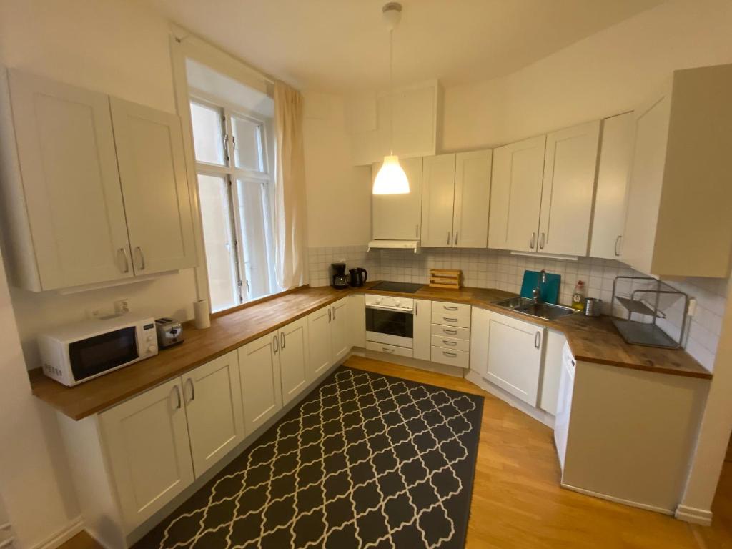 斯德哥尔摩Home Inn KHT15的厨房配有白色橱柜和厨房地毯。