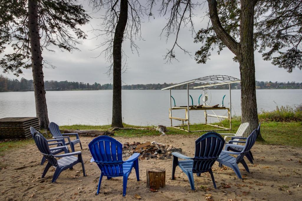 布雷纳德Waterfront Brainerd Cabin with Rice Lake Access!的一群椅子坐在湖边的沙滩上