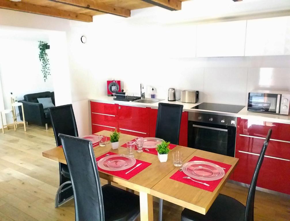 格勒诺布尔Le Paisible - Gare - Duplex - Garage privé - Netflix的厨房配有红色橱柜的木桌