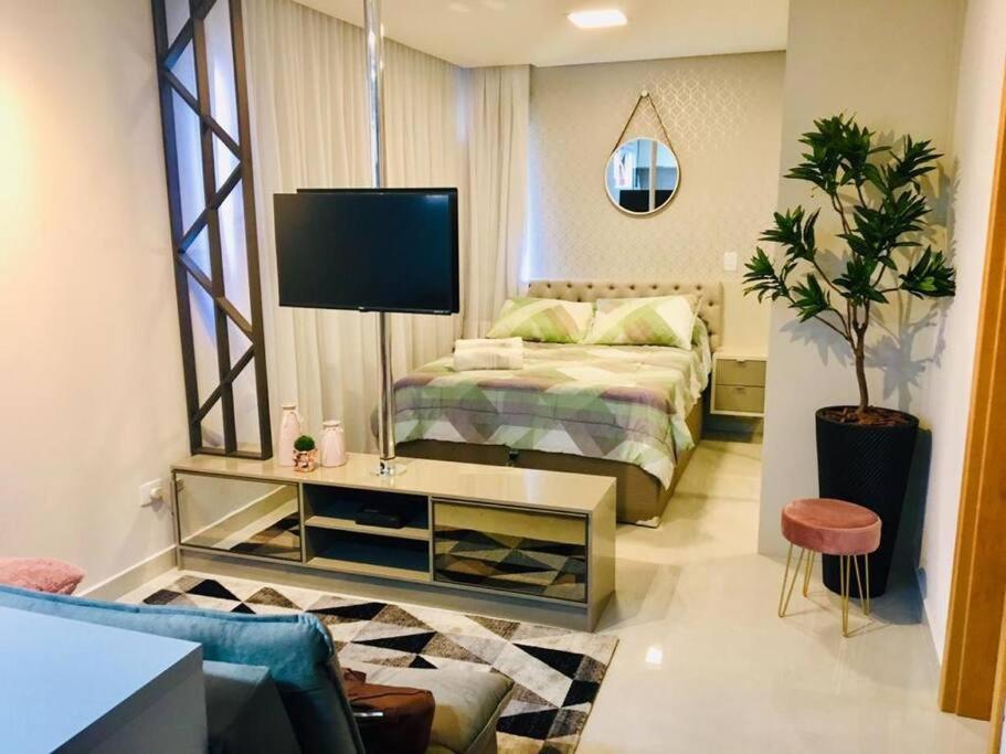 库里提巴Mi casa Su Casa Apartment Studio 1 a 4 pessoas的一间卧室配有一张床和一台电视。