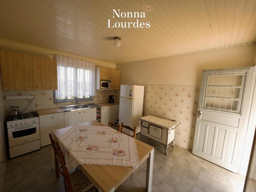 本图贡萨尔维斯Recanto Nonna Lourdes - Vale dos Vinhedos的一间带桌子的厨房和一间带冰箱的厨房