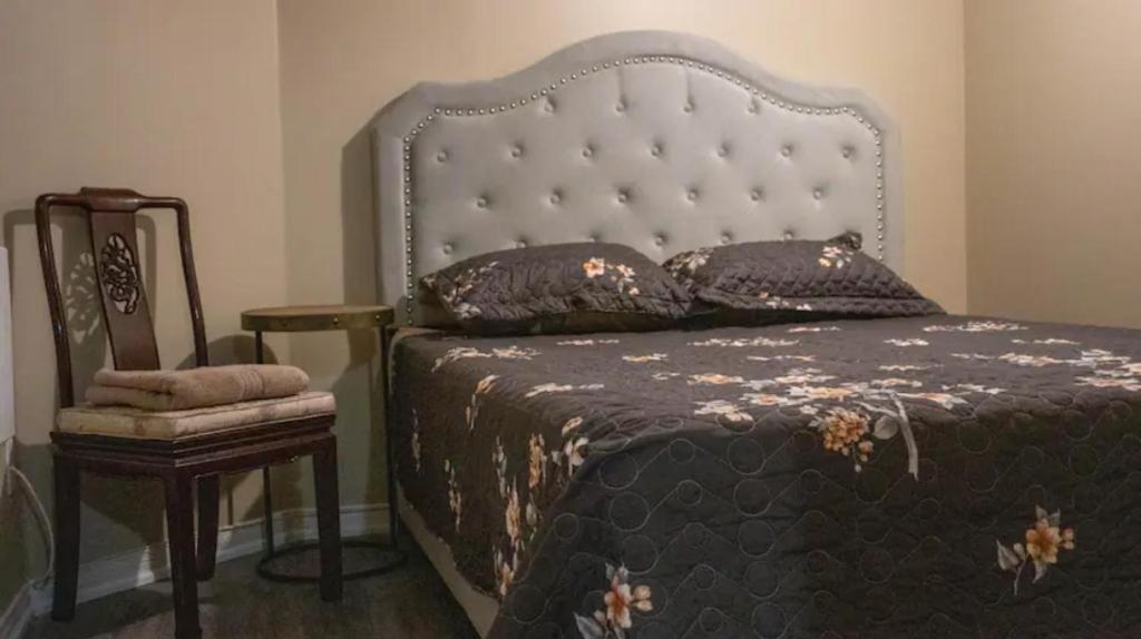 米西索加Riaz's Peaceful Mississauga Home的一间卧室配有一张大床和一把椅子