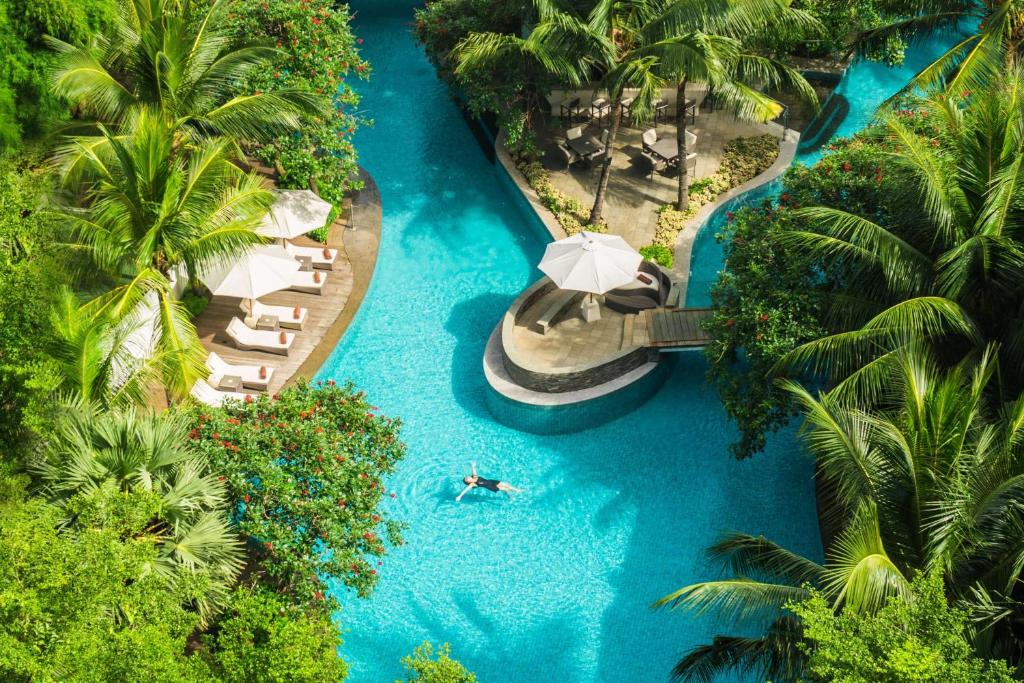 雅加达雅加达希尔顿逸林酒店 - 迪本尼格罗的享有带游泳池和遮阳伞的度假村的空中景致