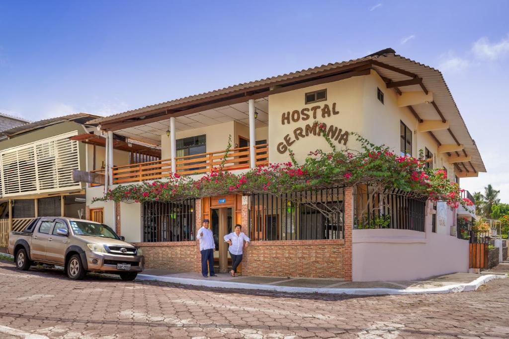 阿约拉港尔曼尼亚旅馆的两个人站在一座建筑前面