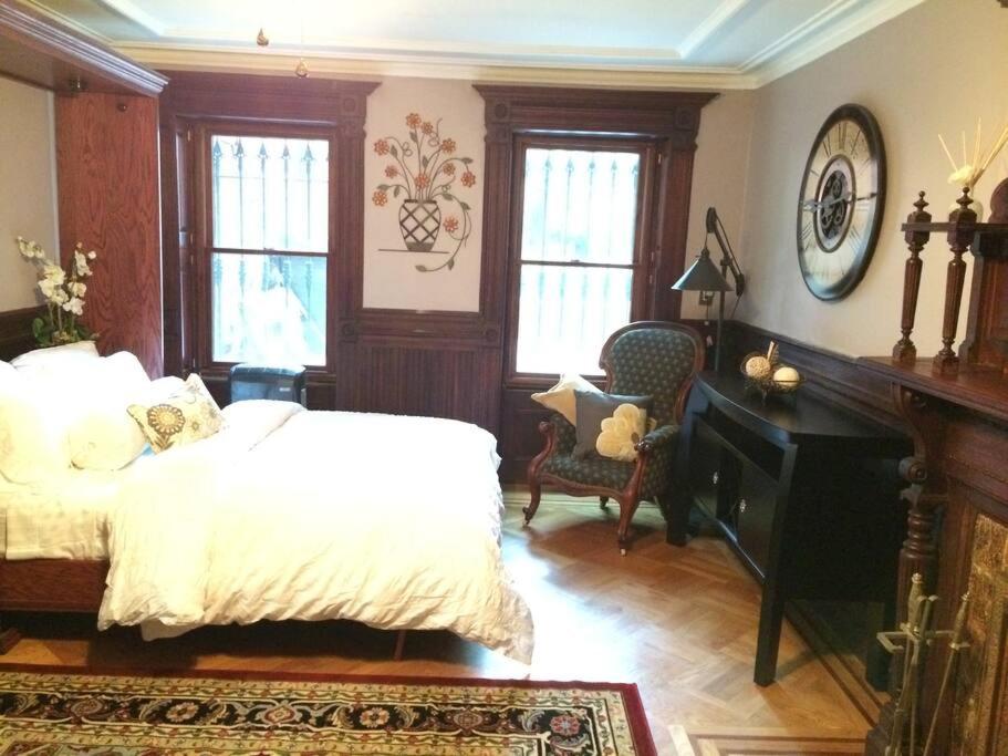 布鲁克林Garden Apartment with Private Entry的卧室配有一张床、一张书桌和窗户。