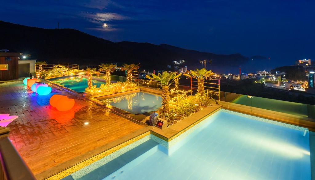 巨济Friemily Pool Villa & Hotel的夜晚屋顶上两个游泳池的景色