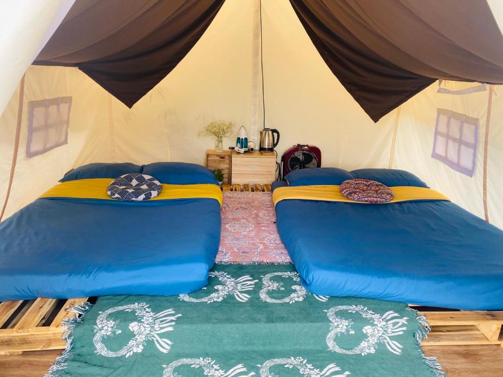 大叻Ma Lá Glamping Đà Lạt的帐篷内带两张床的房间