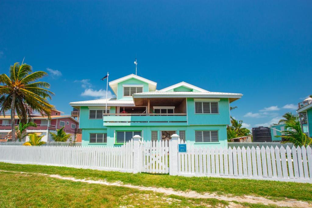 伯利兹城Casa Al Mar, St. George's Caye - Belize的白色围栏后面的蓝色房子