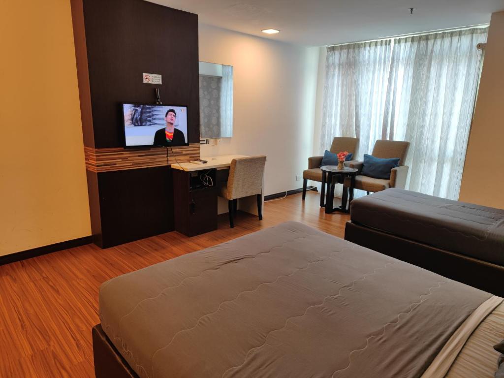 哥打巴鲁Wan's Studio (Kota Bharu City Point)的配有一张床和一台平面电视的酒店客房