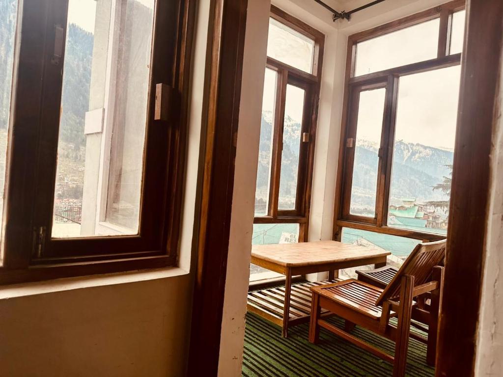 马拉里Hotel Alpine的窗户间里的桌椅