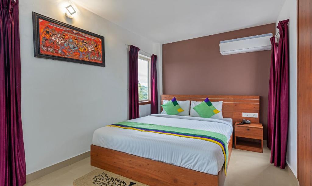 特里凡得琅Treebo Trend JP Residency的一间卧室设有一张床和一个窗口