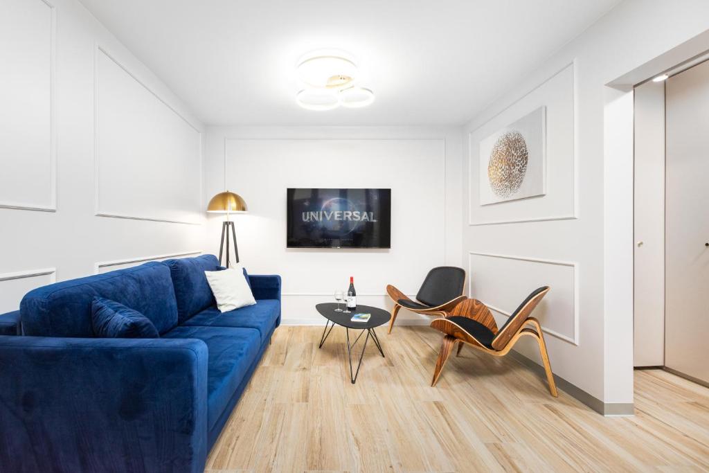 华沙Apartament Grzybowska Premium by Your Freedom的客厅配有蓝色的沙发和椅子