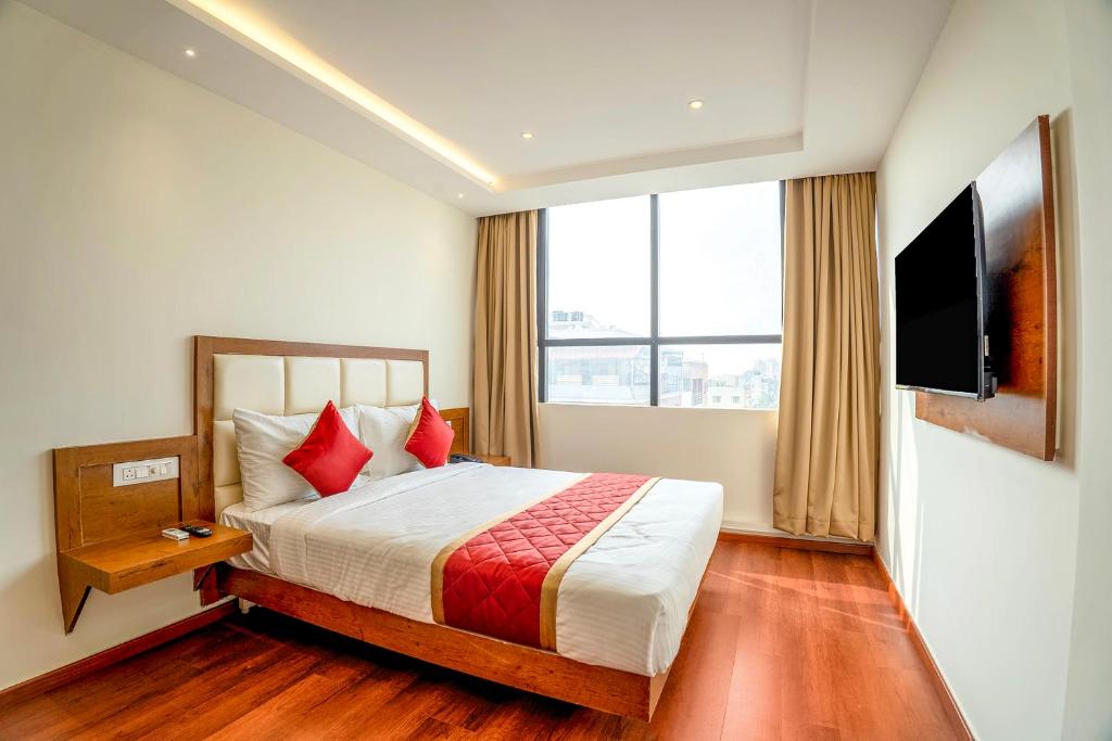 班加罗尔FabHotel Phoenix Horamavu的酒店客房,配有床和电视