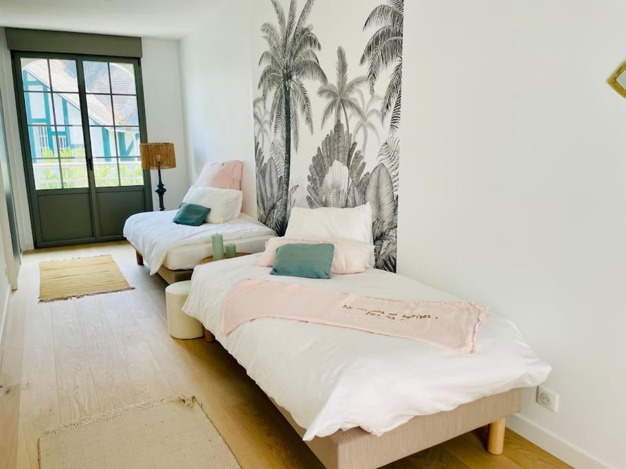 拉波勒Villa Mary-Alex La Baule的墙上棕榈树间内的两张床