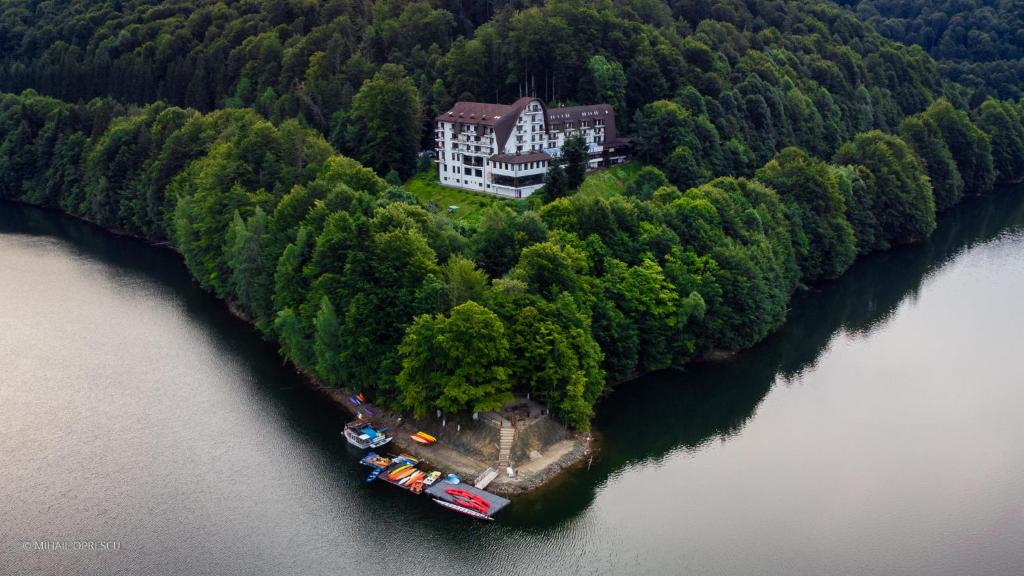 Căpăţîneni-Ungureni鱼谷酒店的水面上岛上房屋的空中景观