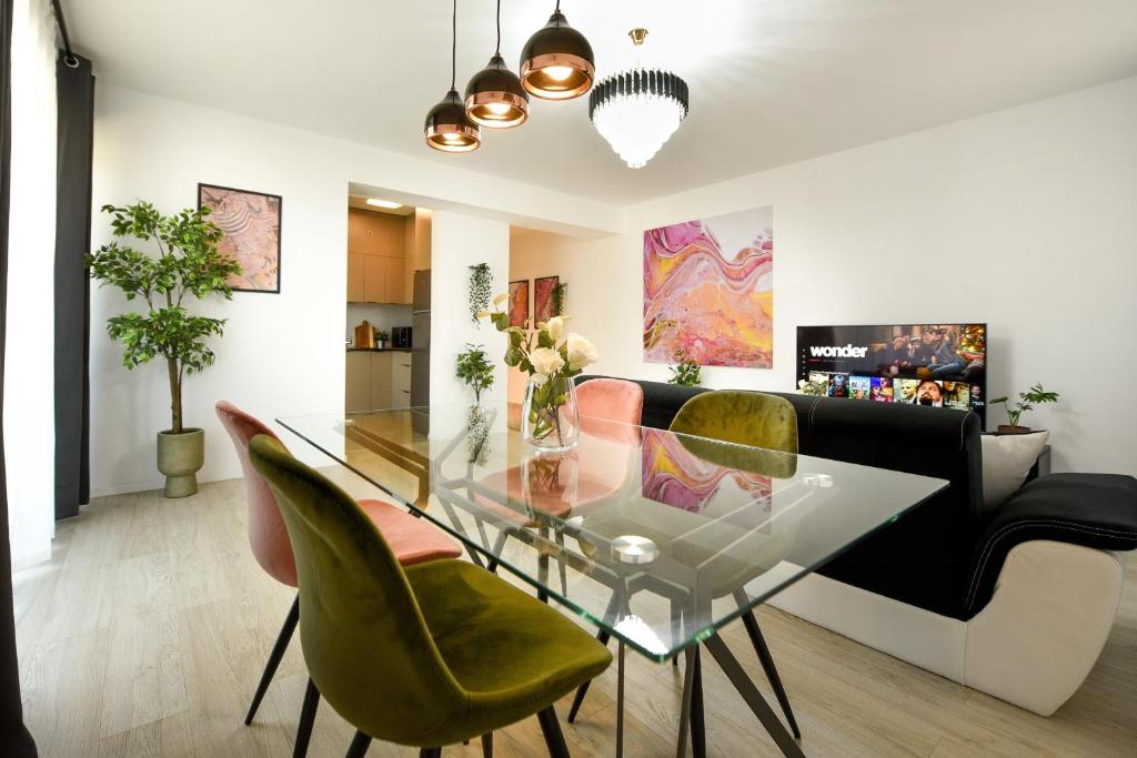 沃伦塔里Urban Bliss - Contemporary Elegance in Modern Living Spaces的一间设有玻璃桌和绿色椅子的用餐室