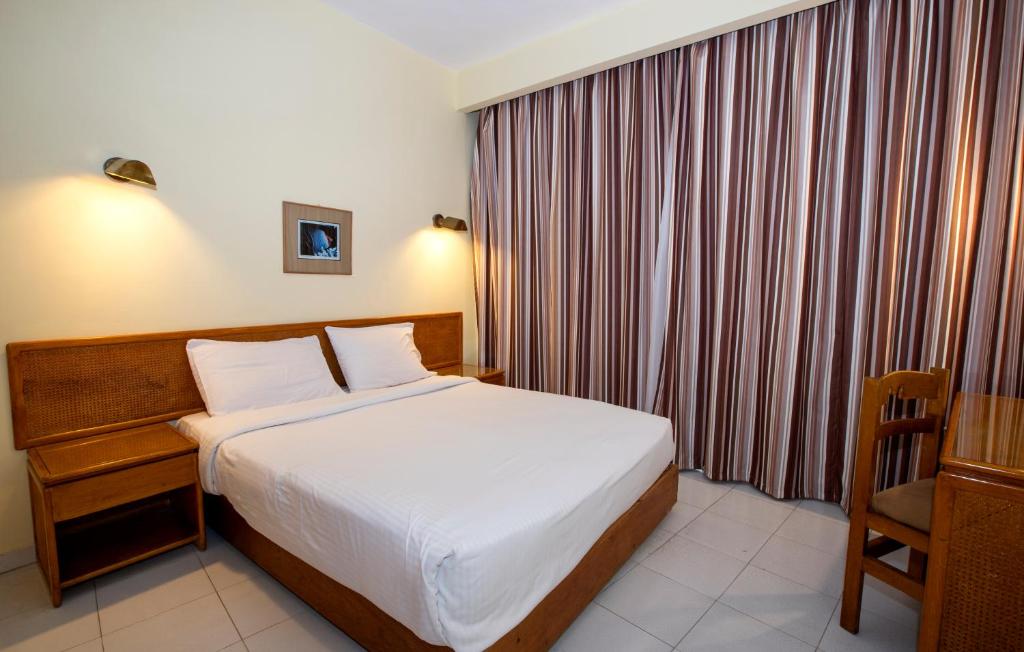赫尔格达Sunny Days Mirette Family Resort的配有一张床和一把椅子的酒店客房