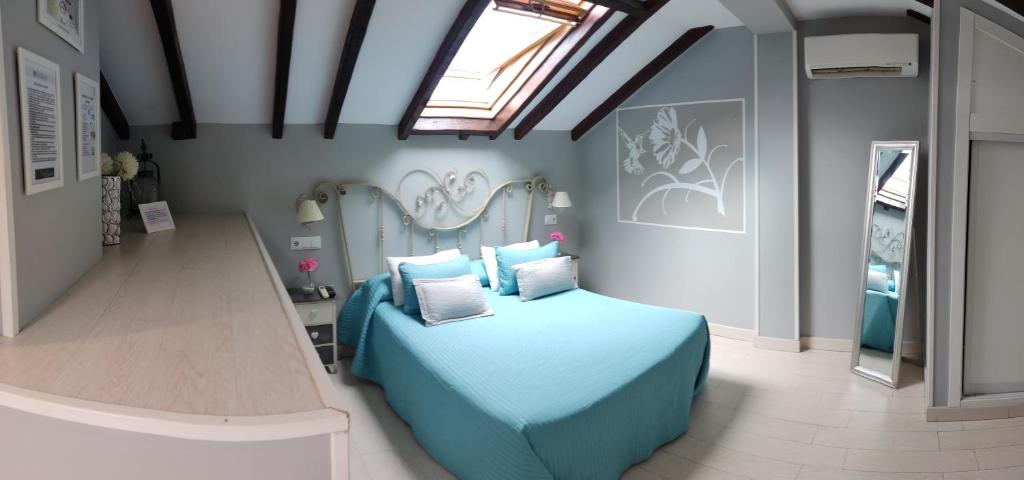 塞哥维亚旧金山霍斯佩达雅酒店的一间卧室设有蓝色的床和天窗