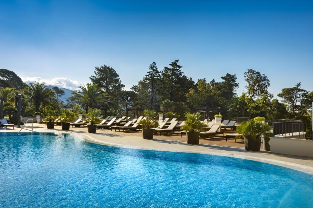 拉布Imperial Valamar Collection Hotel的一座带躺椅和山脉的酒店游泳池