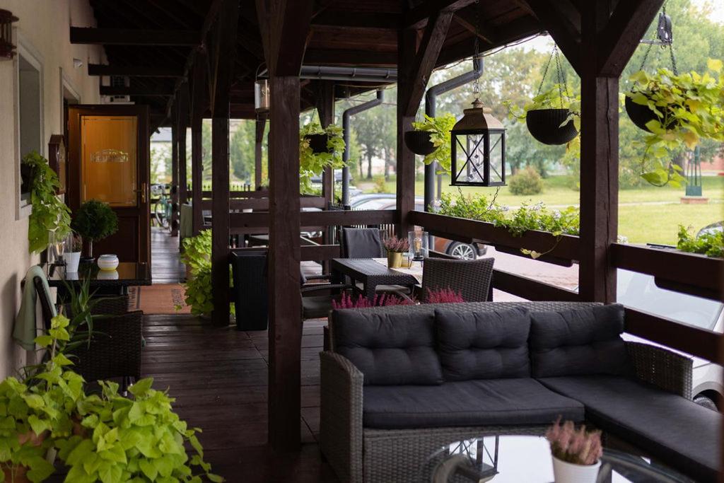 扎莫希奇Kanclerz的一个带沙发和桌子的门廊,以及植物