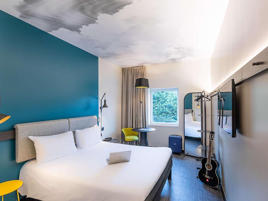 里斯本宜必思里斯本阿尔法莱基德酒店的酒店客房设有白色的床和蓝色的墙壁。