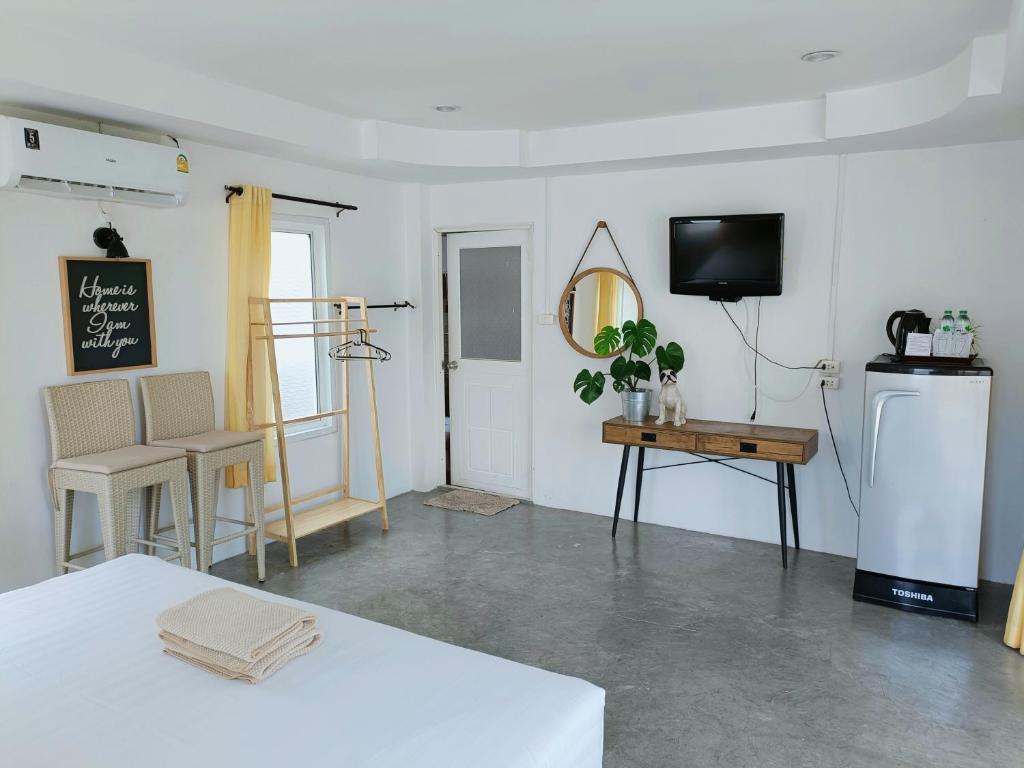 格兰岛Thongtalay Bed & Breakfast Koh Larn的客房设有冰箱、桌子和电视。