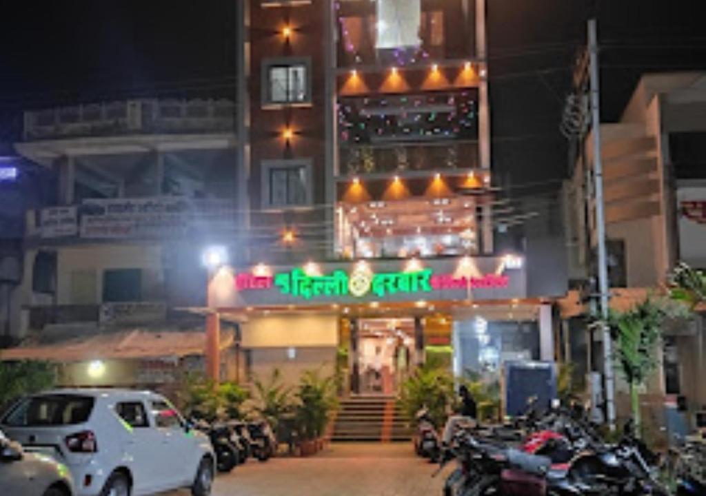 JālgaonHotel New Delhi darbar family restaurant Jalgaon的一间晚上停在餐厅前面的汽车餐厅