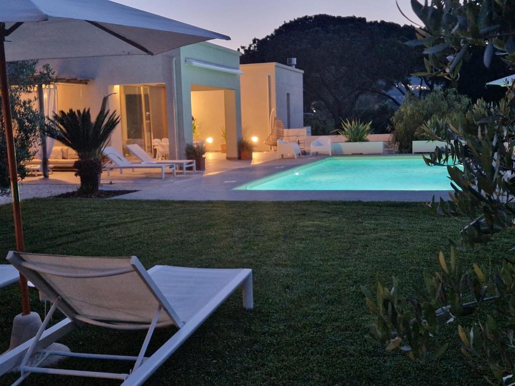 费拉约港La Suite con Piscina Privata的游泳池旁的椅子和遮阳伞