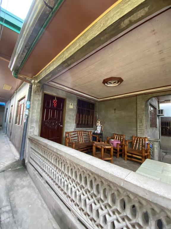 马比尼Perucho-Silang Guest House的阳台,配有桌椅