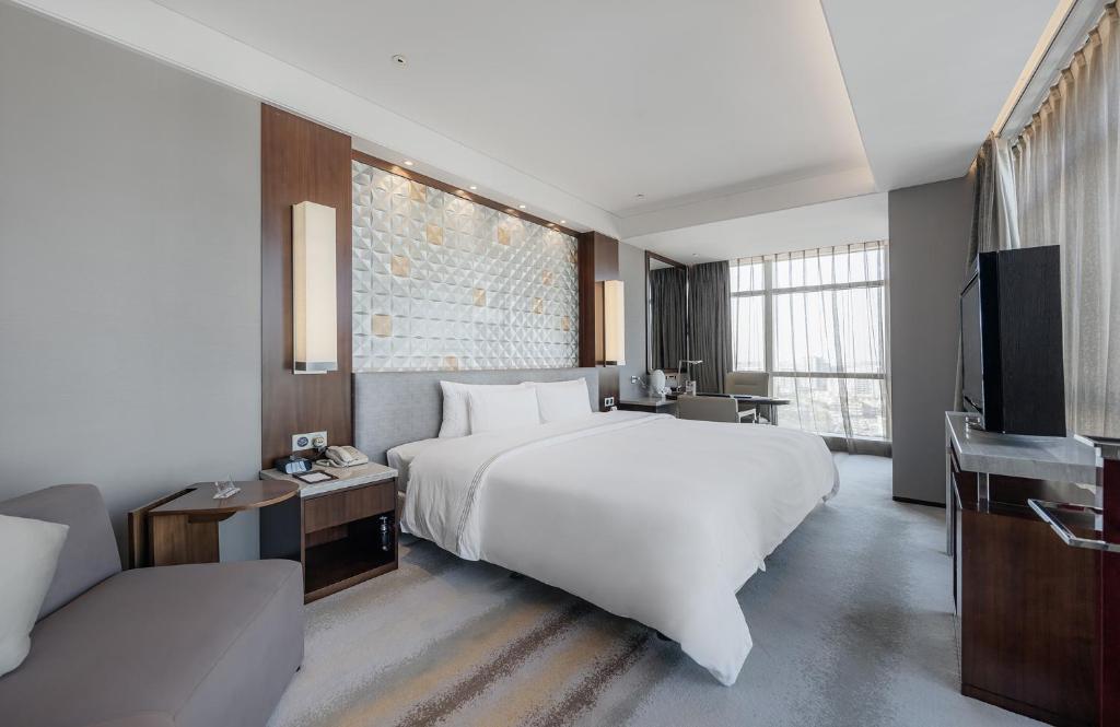 苏州苏州日航酒店的卧室配有一张白色大床和电视。