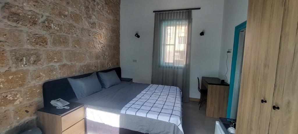 法马古斯塔Bella Casetta Guest House的一间卧室设有一张床和砖墙