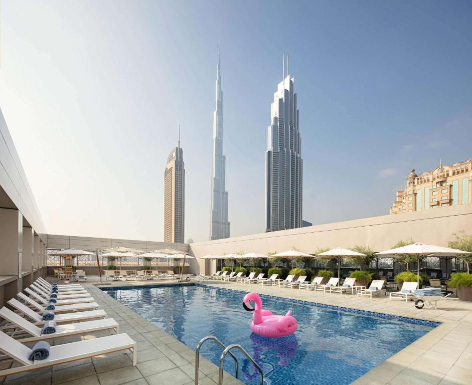 迪拜迪拜市中心罗弗酒店的一座城市中一座游泳池,里面装有粉红色的火烈鸟