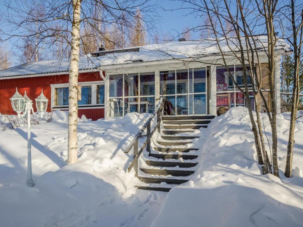 AhmovaaraHoliday Home Villa blanca by Interhome的一座红房子,台阶上下雪