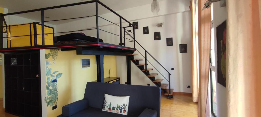 米兰la casa di amy - loft corvetto的客厅设有蓝色的沙发和楼梯。