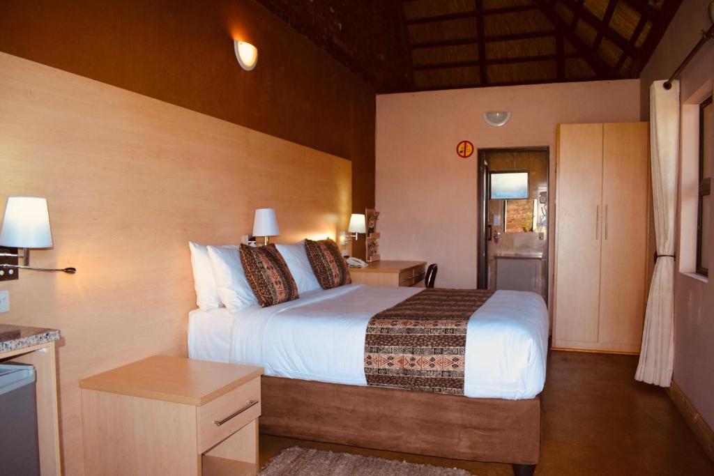 KingsmeadLovely safari room in Harare - 2181的一间带大床的卧室和一间厨房