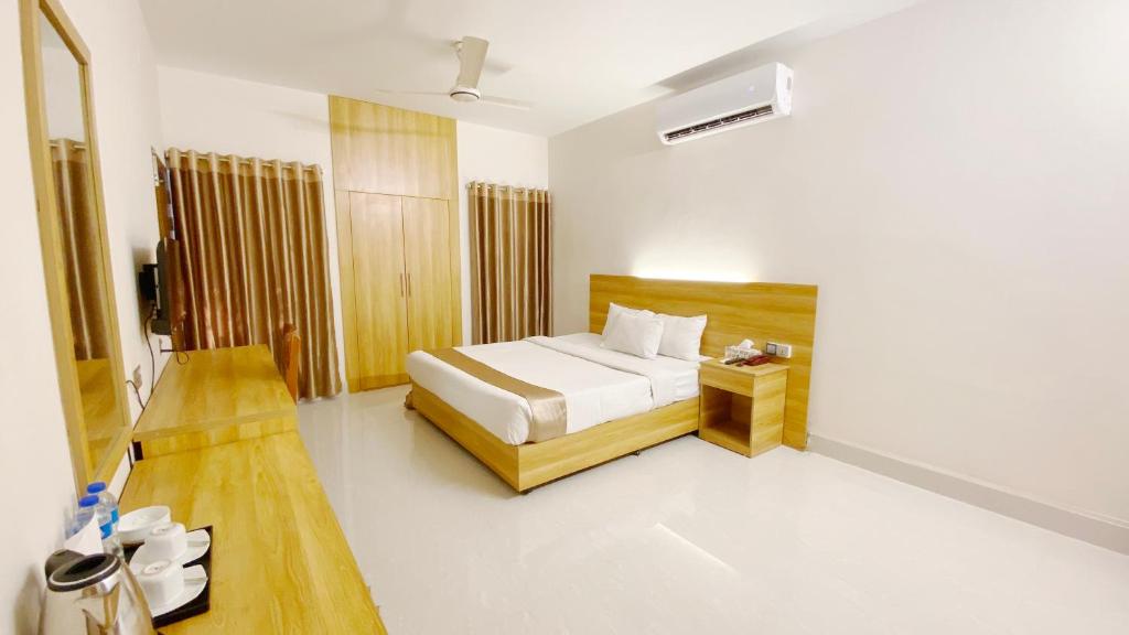 达卡Crown Palace Residence的一间卧室配有一张床和一张桌子