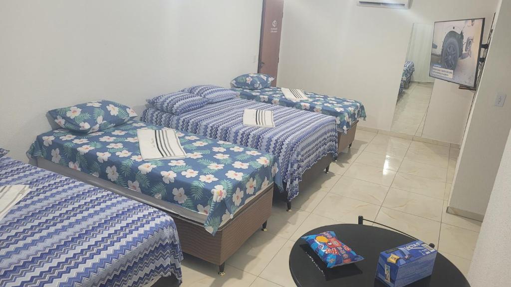 马塞约Suite Pajuçara的客房设有两张床和一张带床垫的桌子。