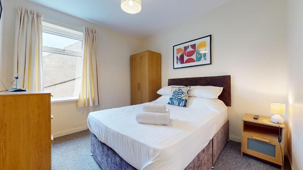 格里姆斯比K Suites - Park Street的一间卧室设有一张大床和一个窗户。