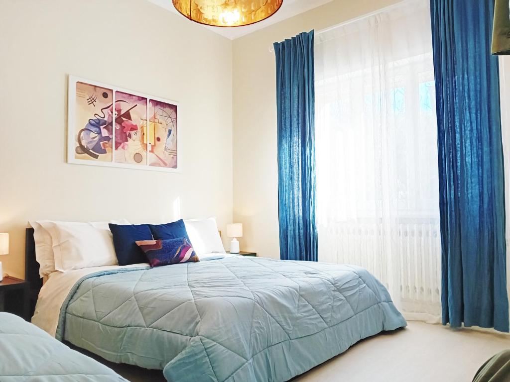 里乔内CasaRava Sul Parco的一间卧室配有床和蓝色窗帘的窗户