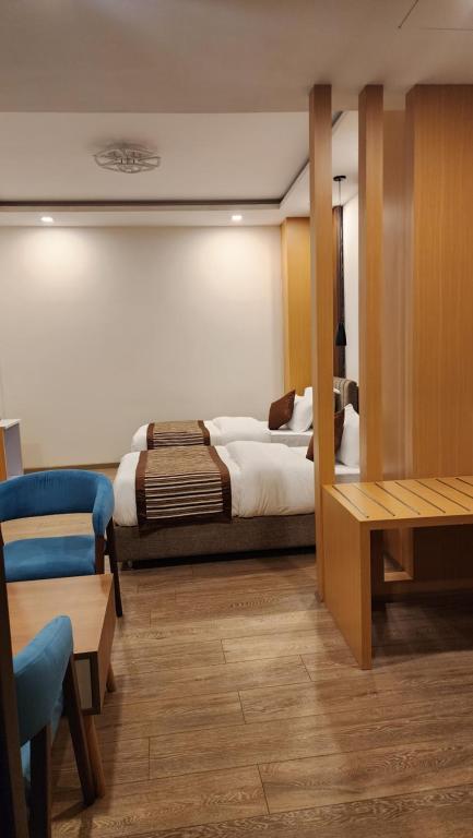 加德满都Prudential Hotel Nepal的卧室配有1张床、1张桌子和1把椅子