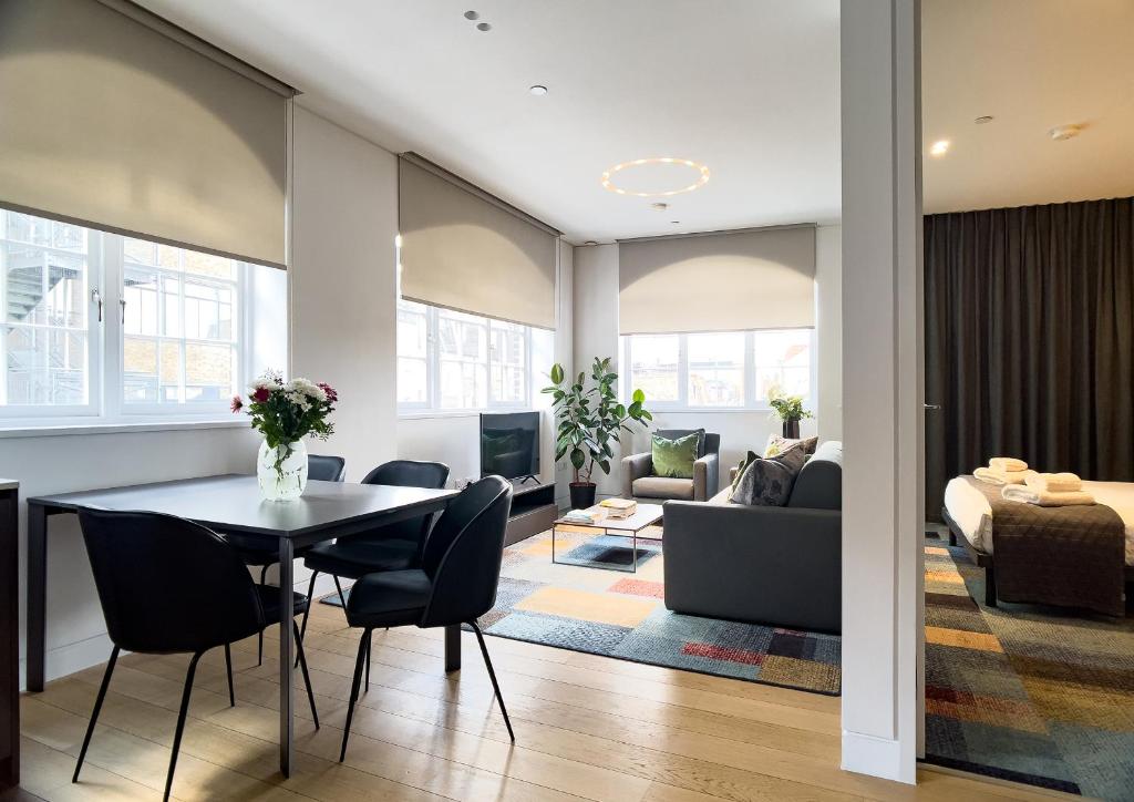 伦敦Mirabilis Apartments - Bayham Place的用餐室以及带桌椅的起居室。