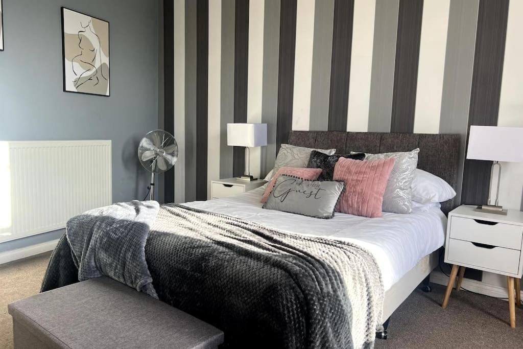 科尔切斯特Luxury Suite in Colchester Town Centre By Station的一间卧室配有一张带条纹墙的床