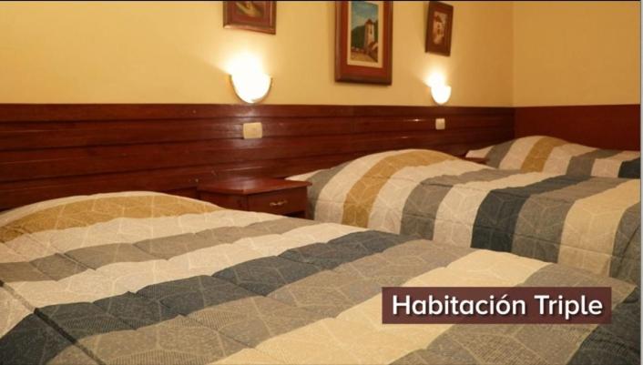 ChalhuancaHOTEL ZEGARRA的两间相邻的床铺位于酒店客房内